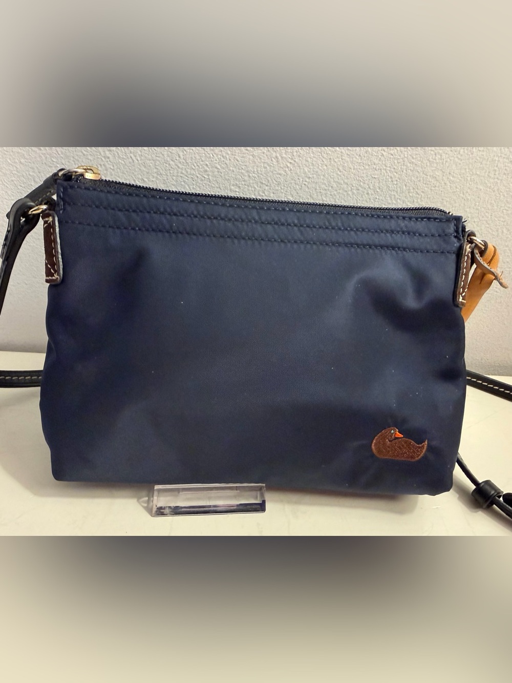Dooney & Bourke navy nylon crossbody with leather trim & embroidered duck.